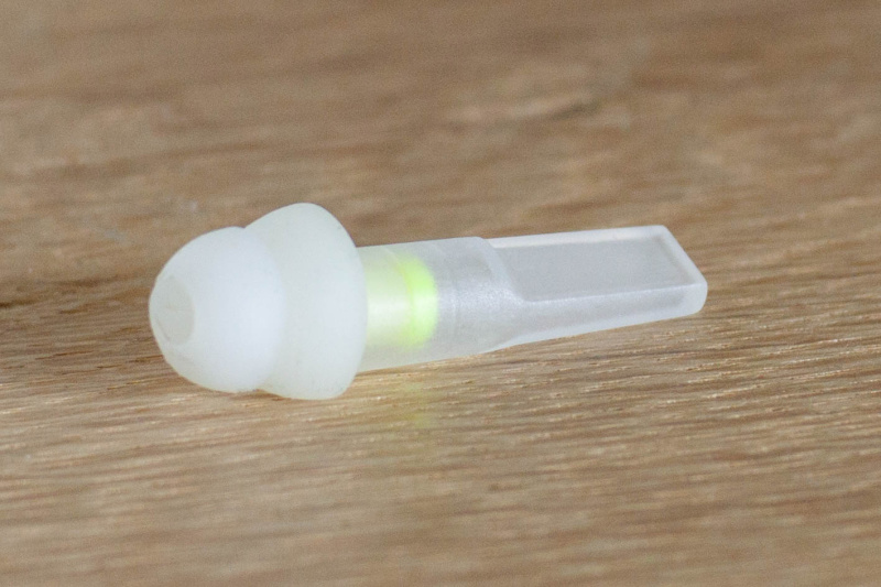 Einzelner FlyFit Ohrstöpsel mit aufgesteckter Hülse zum Einsetzen ins Ohr